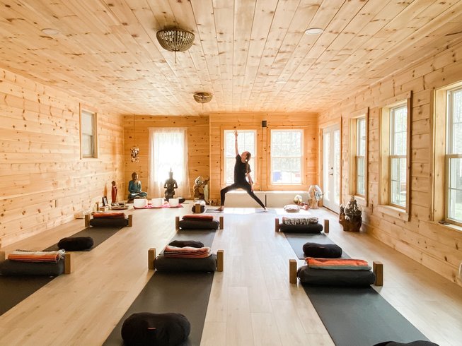 Interior of Santosha Yoga studio in Kingfield, Maine, with wood-paneled walls and mats arranged for a class